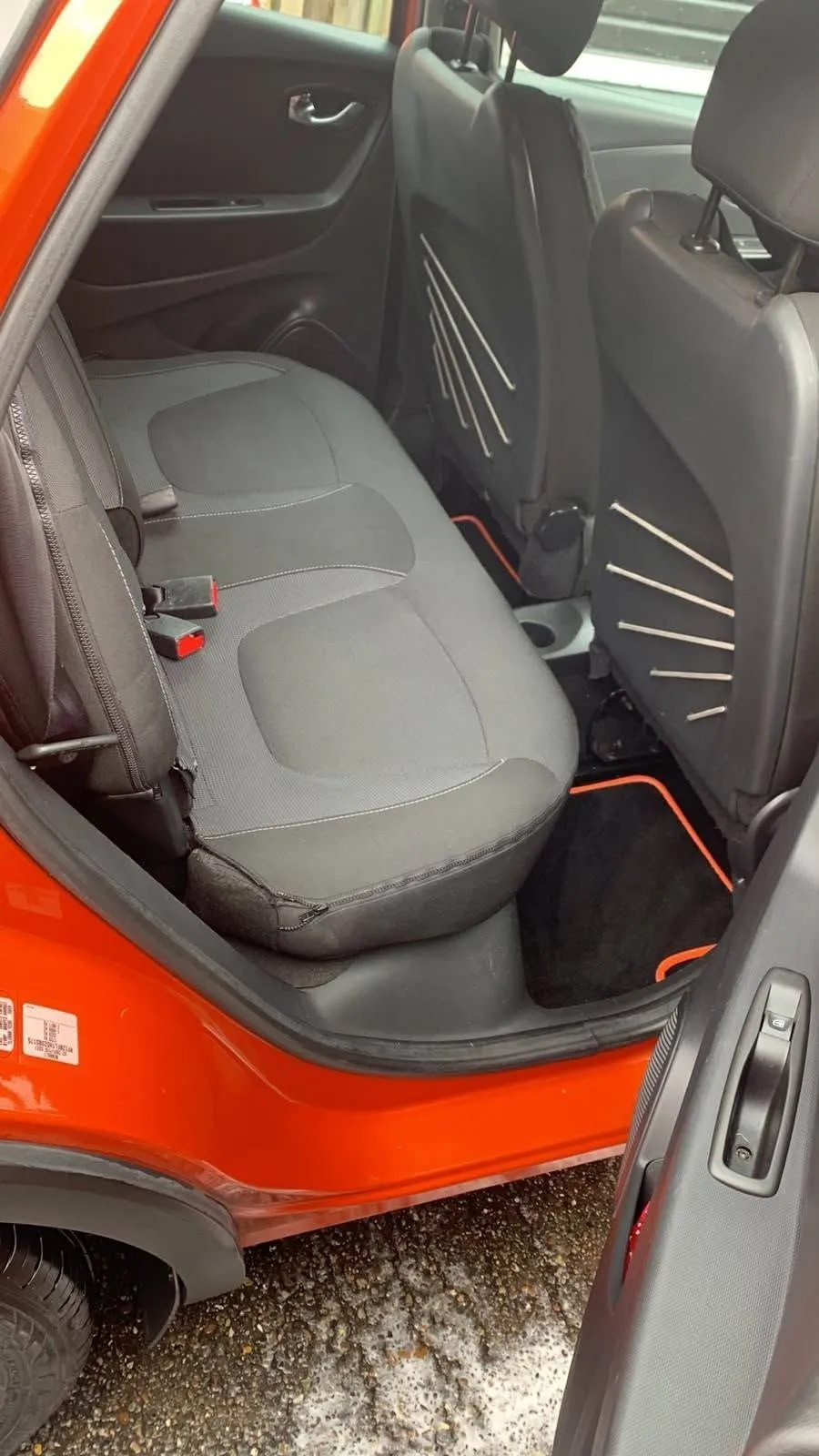 Rear seats of an orange Renault Captur, cleaned, door open