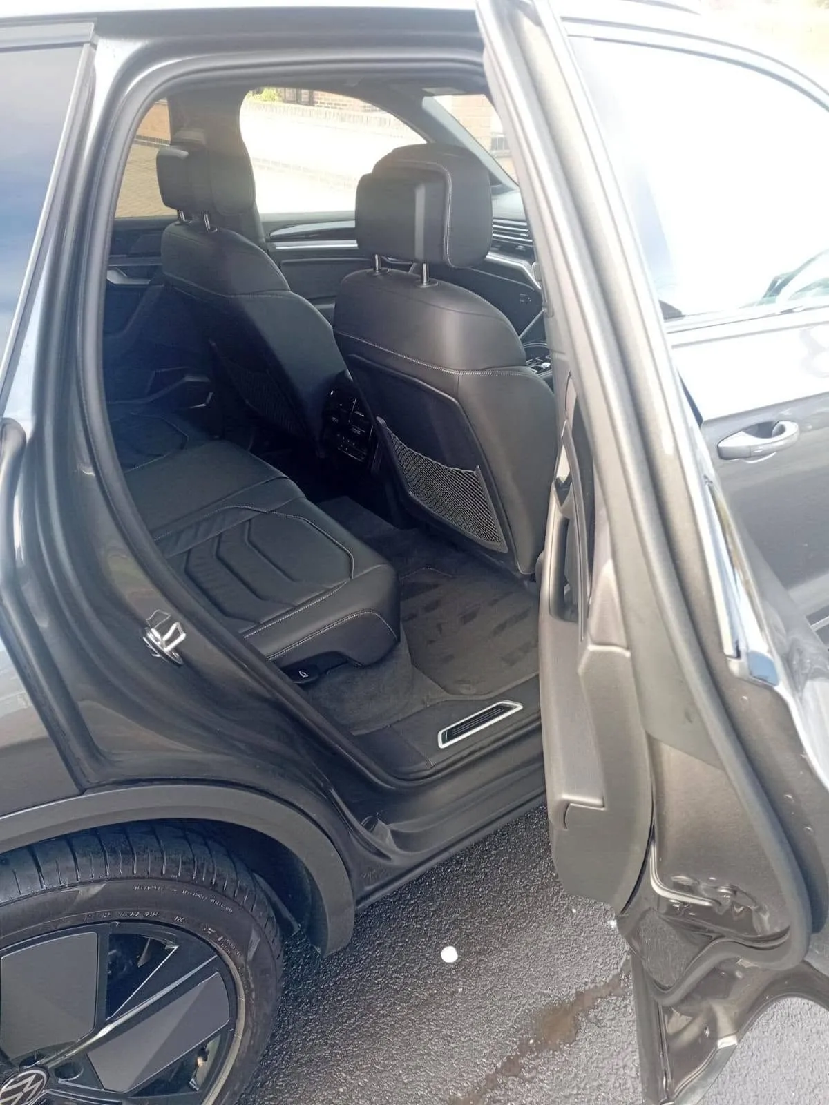 Rear seats of a grey Volkswagen Touareg through the open door, cleaned